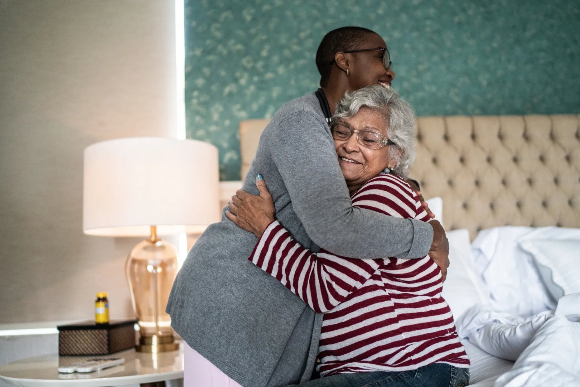 Caregiver hugging elderly patient