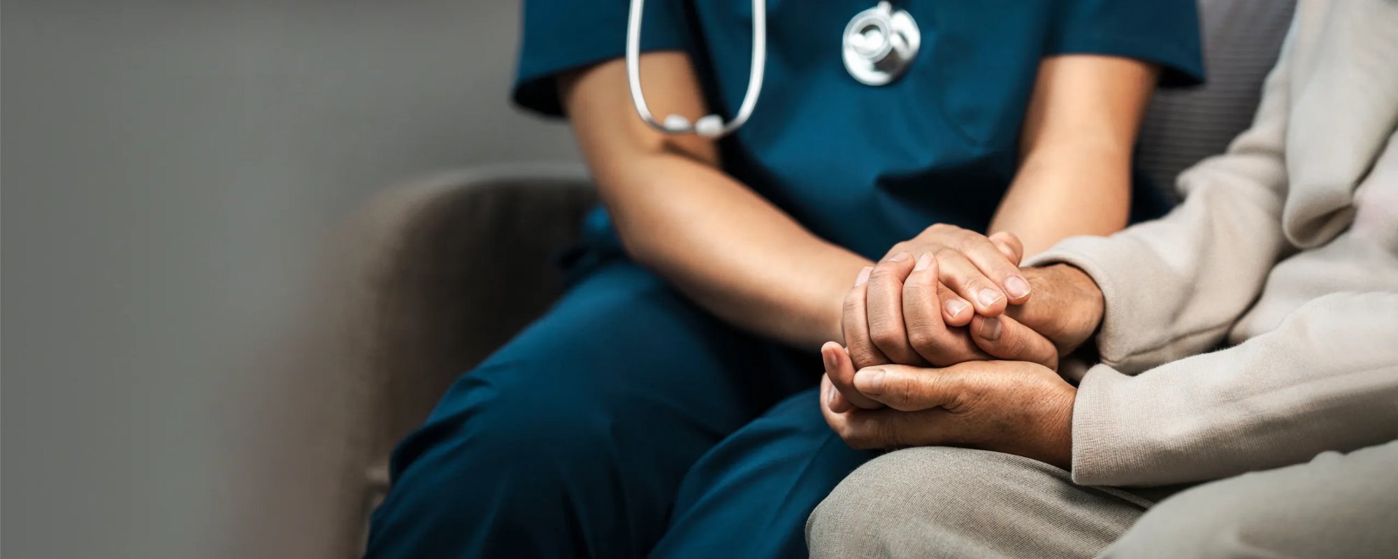 Nurse holding patient's hands with care